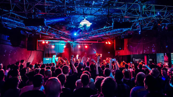 An image of a crowd at Satellite bathed in a red and blue light